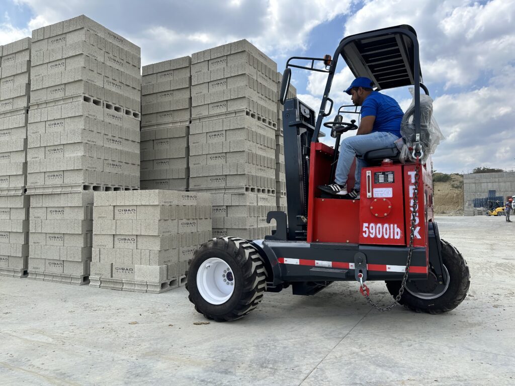 Montacargas tipo piggyback de 5900 lb operando frente a bloques de concreto en zona industrial