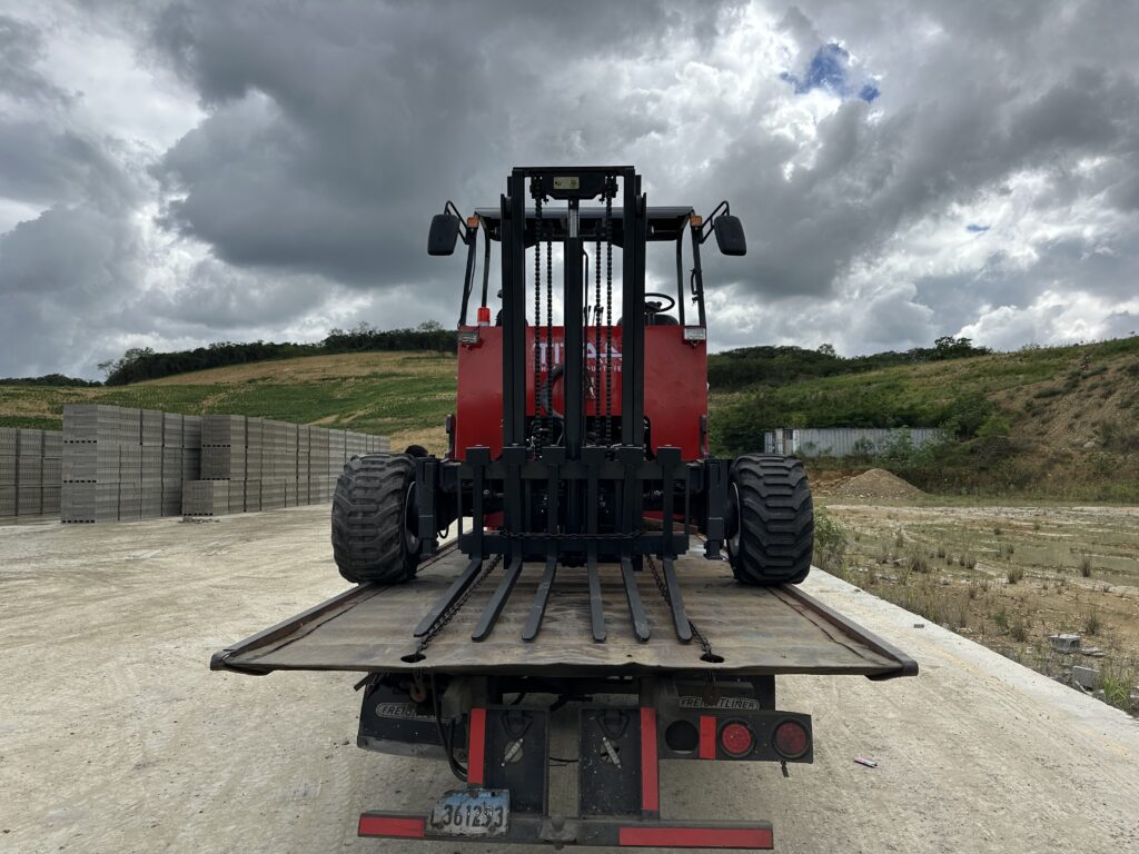 Montacargas tipo Piggyback rojo montado en la parte trasera de un camión en un área industrial